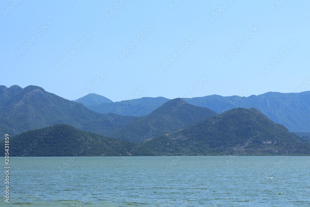 Blue background with calm sea and mountains. montenegro Blue background with calm sea and mountains. montenegro