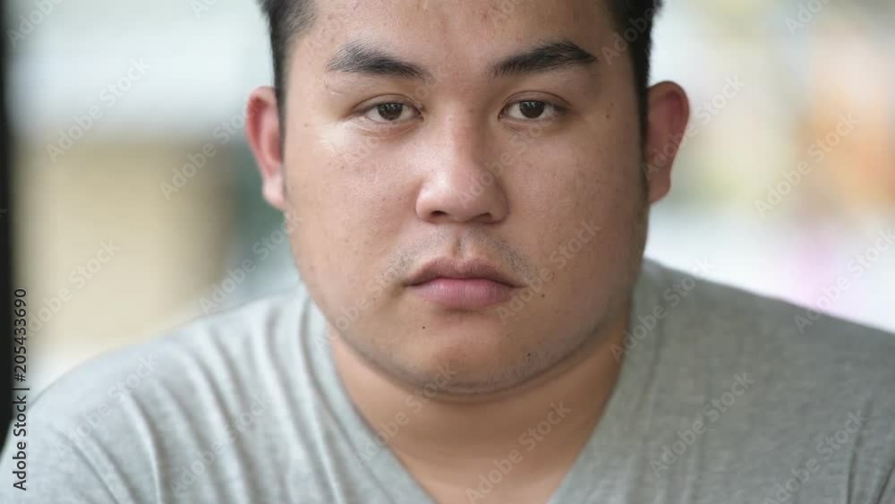 Young handsome overweight Asian man relaxing at the coffee shop Young handsome overweight Asian man relaxing at the coffee shop