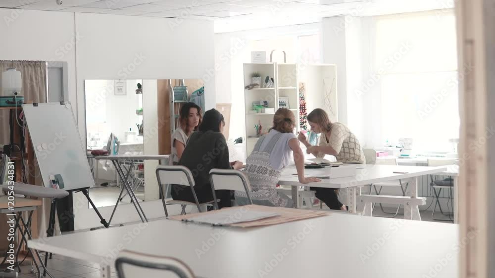 Fashion designers in small business startup company sit in the atelier at their desk and do business planning Fashion designers in small business startup company sit in the atelier at their desk and do business planning
