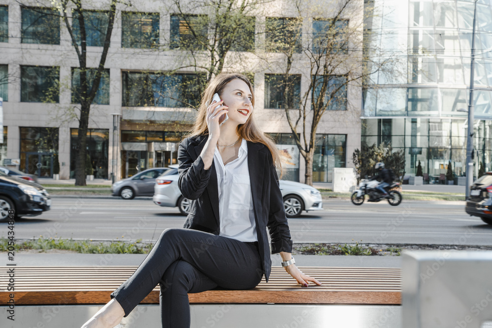 A business woman speaks through the phone. A good girl is sitting on the bench. A young woman in the city center. A business woman speaks through the phone. A good girl is sitting on the bench. A young woman in the city center.