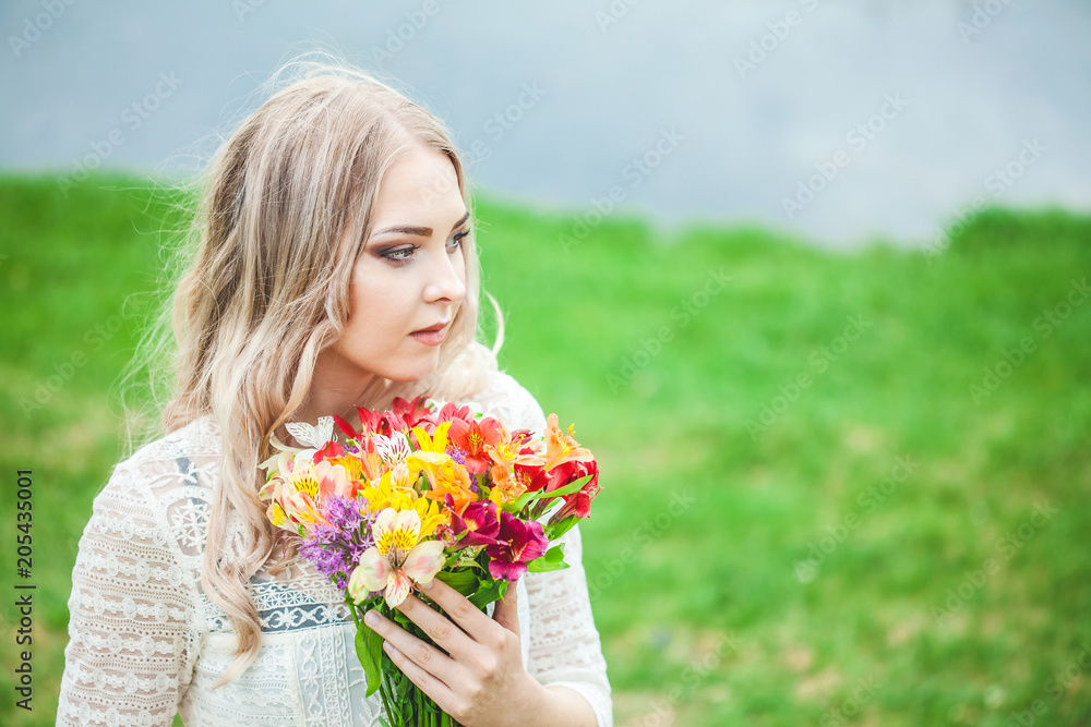 portrait of a blond girl with a bouquet of flowers on a lake background close-up portrait of a blond girl with a bouquet of flowers on a lake background close-up