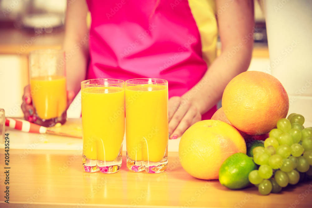 Woman with fresh fruits and juice in kitchen Woman with fresh fruits and juice in kitchen