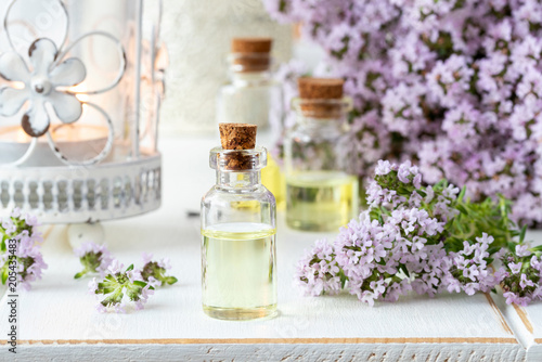 A bottle of essential oil with fresh blooming thyme