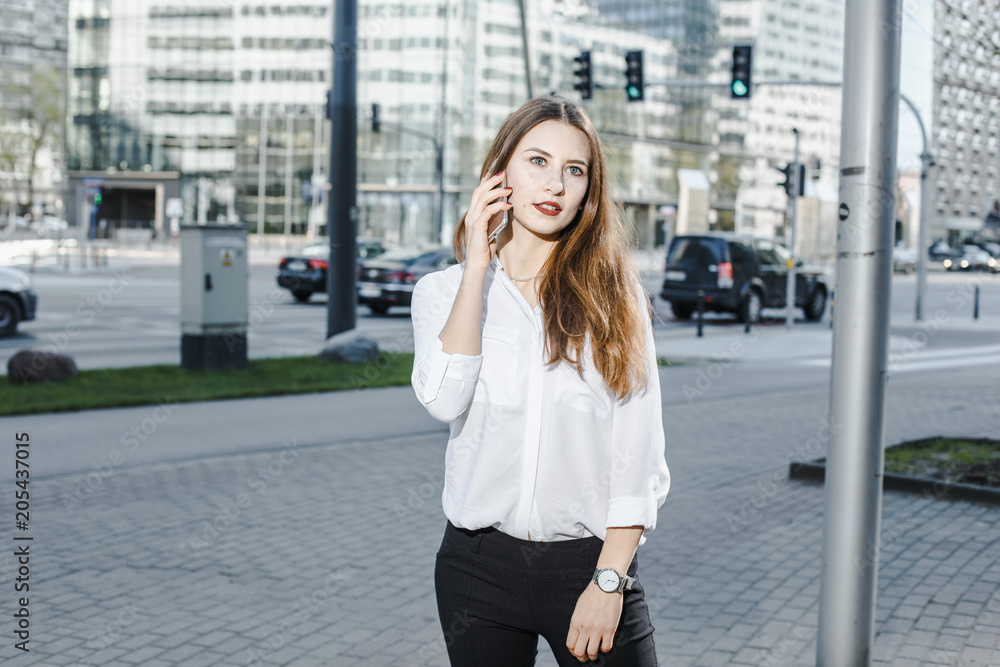 A business woman speaks through the phone. A good girl is sitting on the bench. A young woman in the city center. A business woman speaks through the phone. A good girl is sitting on the bench. A young woman in the city center.
