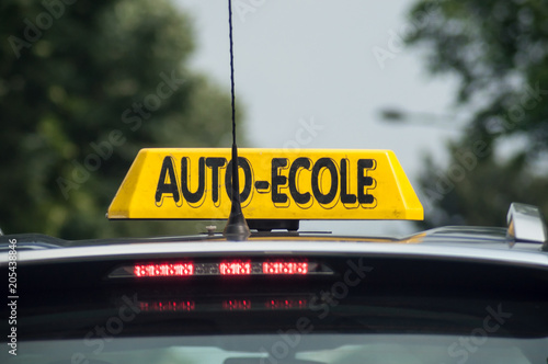 closeup of driving school panel on the car roof in French text