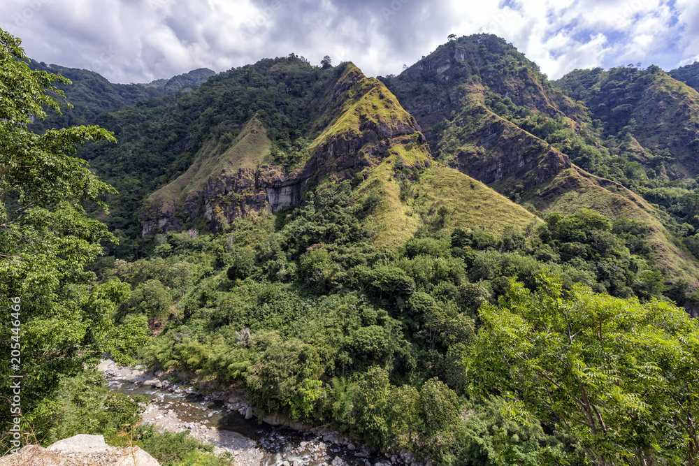 A small river flowing beneat dramatic cliffs near Ende in East Nusa Tenggara, Indonesia.