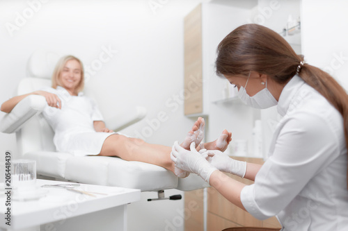 Podiatrist female doctor making procedure of massage and peeling. © IEGOR LIASHENKO