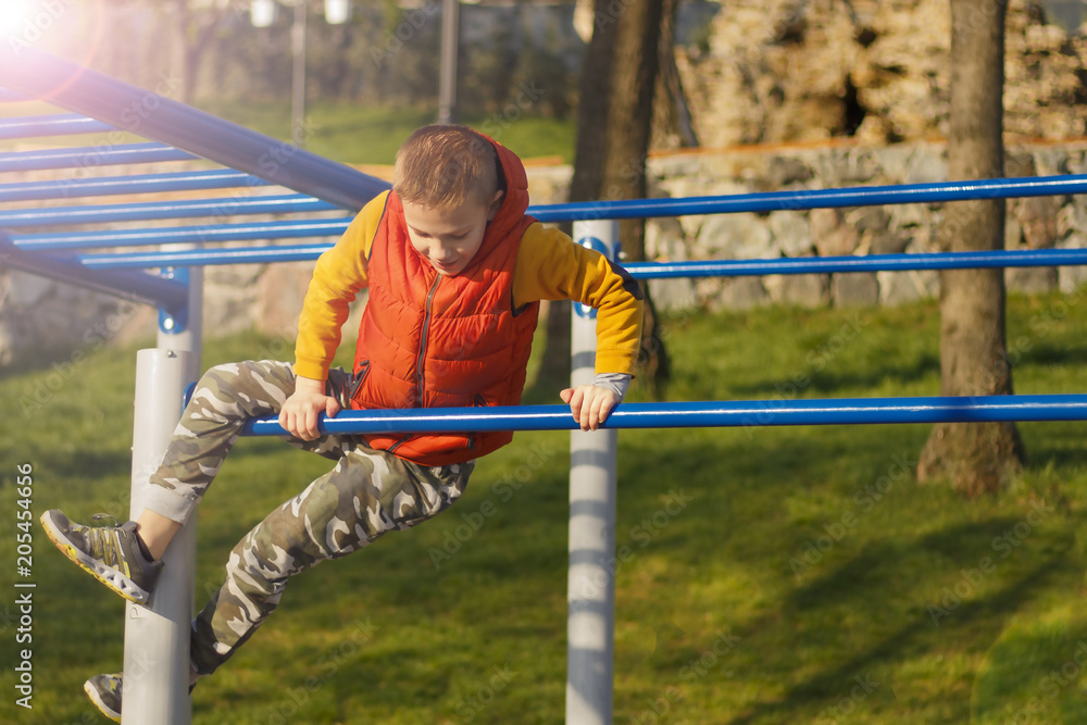 Obraz premium Kid with cool haircut doing fitness outdoor and having fun