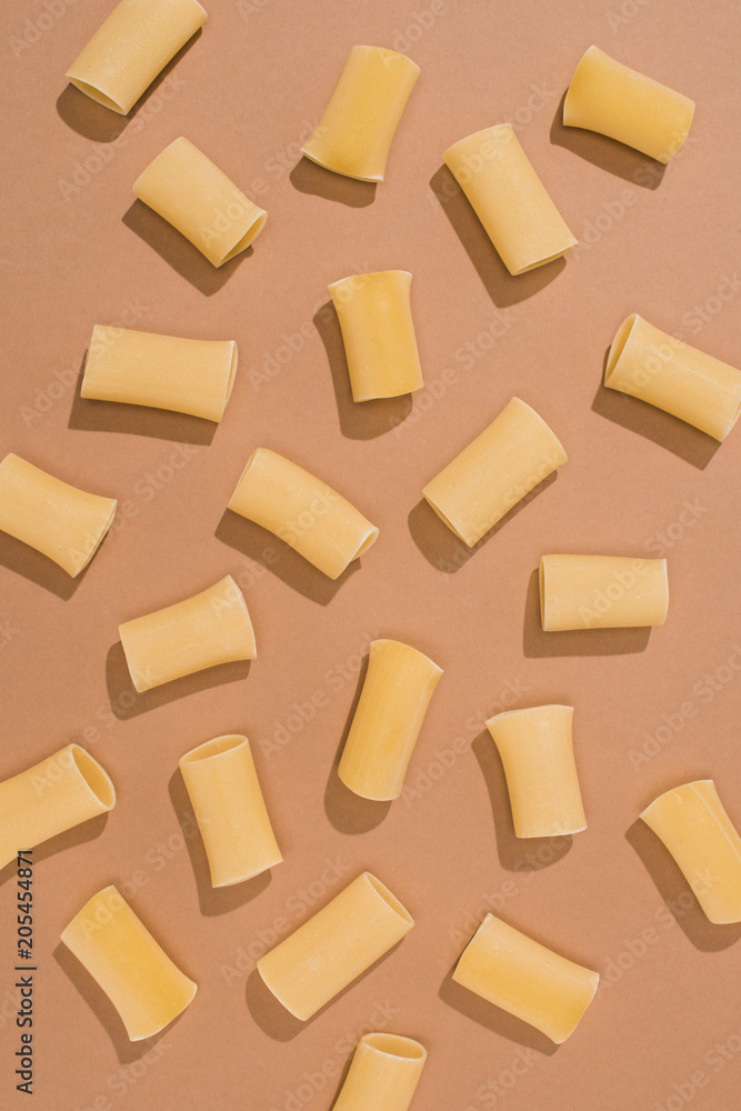 top view of pasta spilled on beige surface top view of pasta spilled on beige surface