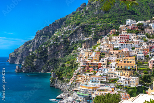 Positano Italy Amalfi Coast Naples - Panoramic view of coloured houses grasping the mountain side and the turquoise Mediterranean sea.