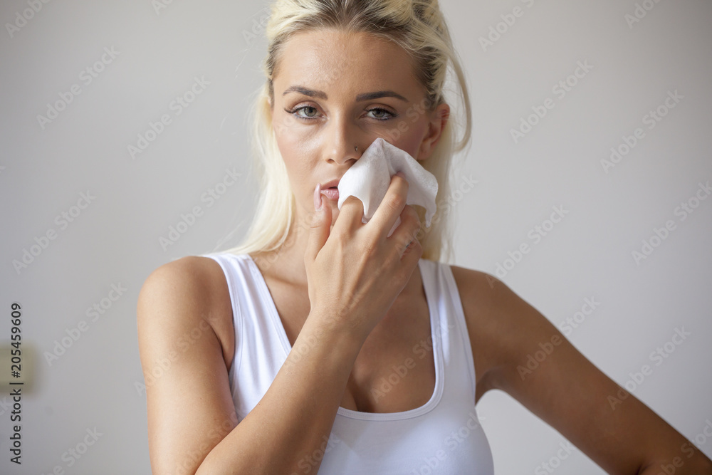 Young woman clean face with wet wipes Young woman clean face with wet wipes