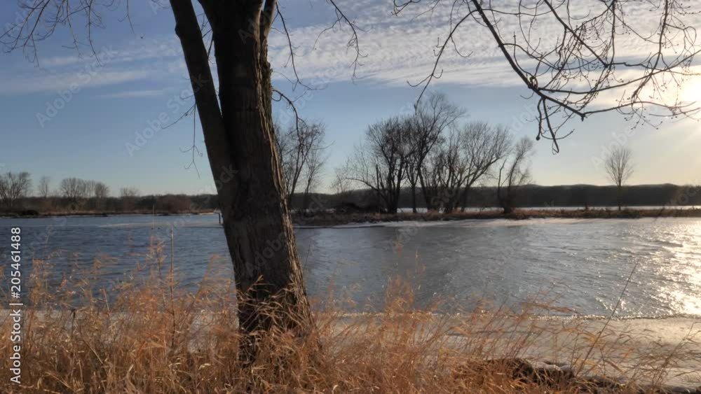 Slow-Motion Camera Pans Right To Reveal Flowing River Underneath Golden Sunset Slow-Motion Camera Pans Right To Reveal Flowing River Underneath Golden Sunset
