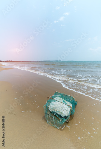 old crab cage with foam on beach © xiaoliangge