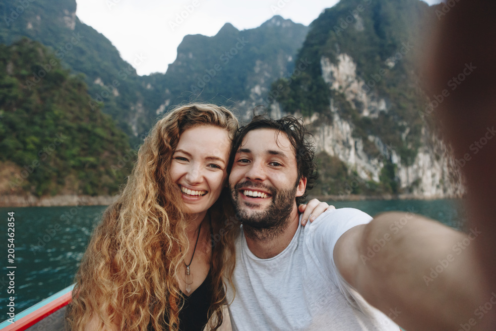 Couple taking selfie on a longtail boat - obrazy, fototapety, plakaty 