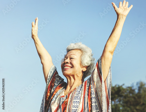 Senior asaian woman raising her arms