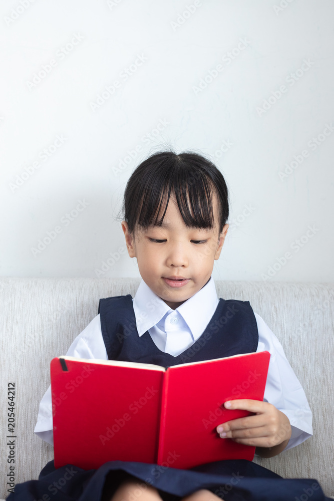 Asian Chinese little girl sitting on the sofa reading book Asian Chinese little girl sitting on the sofa reading book