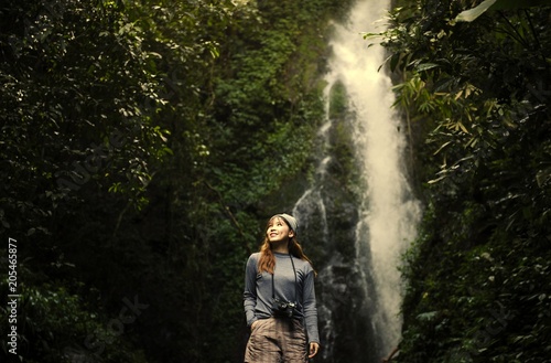 Asian woman enjoying a waterfall