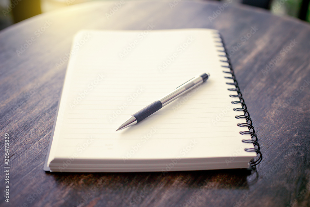 notebook and pen on a wooden table notebook and pen on a wooden table