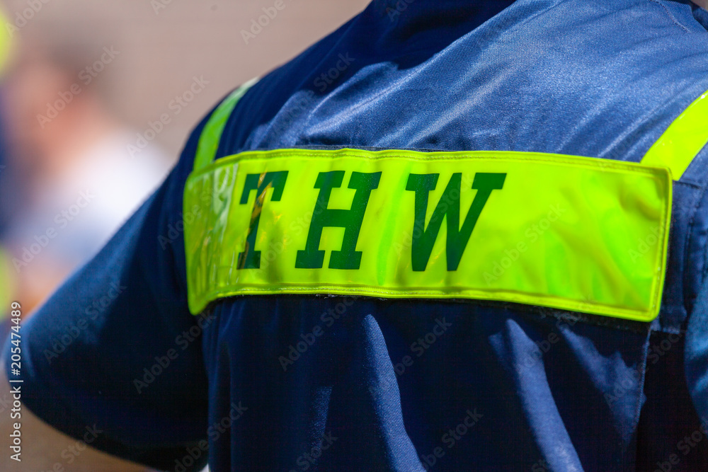 Fototapeta premium German technical emergency service sign on a vest from a man. THW, Technisches Hilfswerk means technical emergency service.