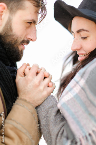 Portrait of american man holding woman hand in white background, wearing coat with scarf. Concept of couple seasonal winter photo session and romantic feelings. photo