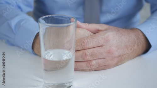 Businessman with a Glass of Water on the Table