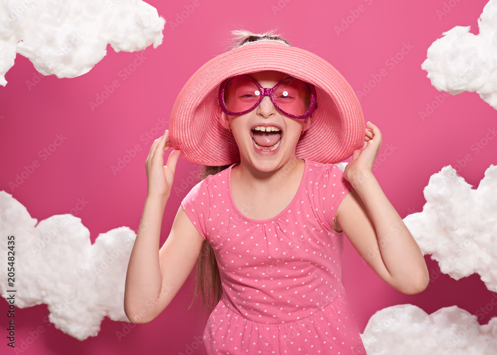 fashionable girl posing on a pink background with clouds, pink dress and hat fashionable girl posing on a pink background with clouds, pink dress and hat