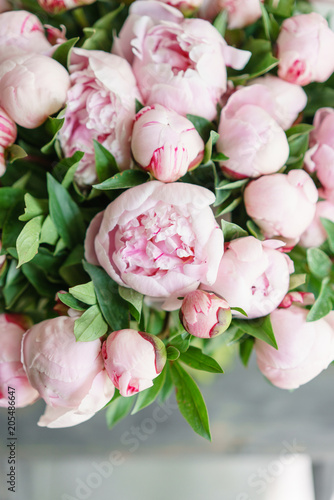 Fototapeta Naklejka Na Ścianę i Meble -  Lovely flowers in glass vase. Beautiful bouquet of pink peonies . Floral composition, scene, daylight. Wallpaper. Vertical photo