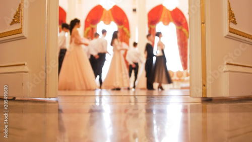 Ladies with cavaliers in vintage costumes dancing waltz photo