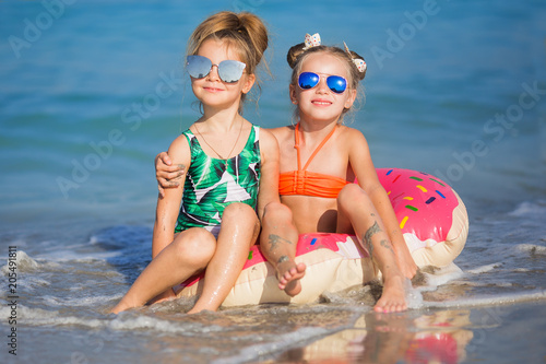 Happy girls on the sea. Cheerful girlfriends float on a circle on the sea