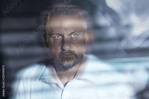 Blurred close-up of a troubled middle-aged man's face with eyes wide open. Depression and mental illness concept.