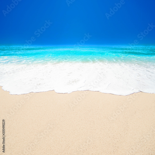 Beautiful Tropical beach with Soft wave of blue ocean, white sand and sky. Summer travel holiday background concept. Sea panorama with copyspace.