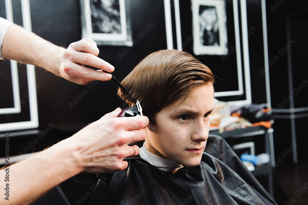 Fototapeta premium cute young boy getting a haircut