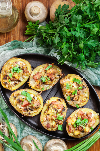 Baked potatoes in jacket stuffed with bacon, mushrooms and chees