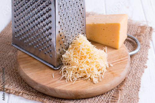 Grated cheese on a wooden cutting board photo