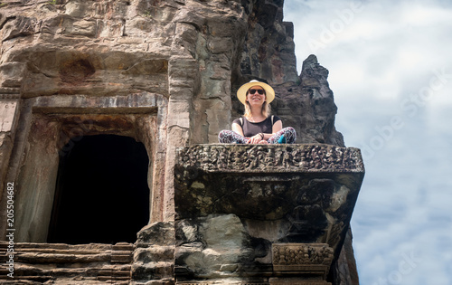 Tourist girl sitting at the temple angkor wat in Cambodia