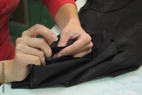 Tailor's business. The hem of the pants manually with a needle and thread