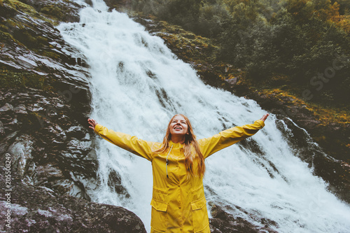 Papier peint Happy smiling woman tourist raised hands enjoying waterfall landscape Traveling
