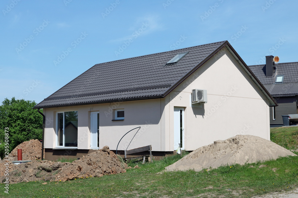 The unfinished standard village house is made of foam concrete and plastered in cream color. The unfinished standard village house is made of foam concrete and plastered in cream color.