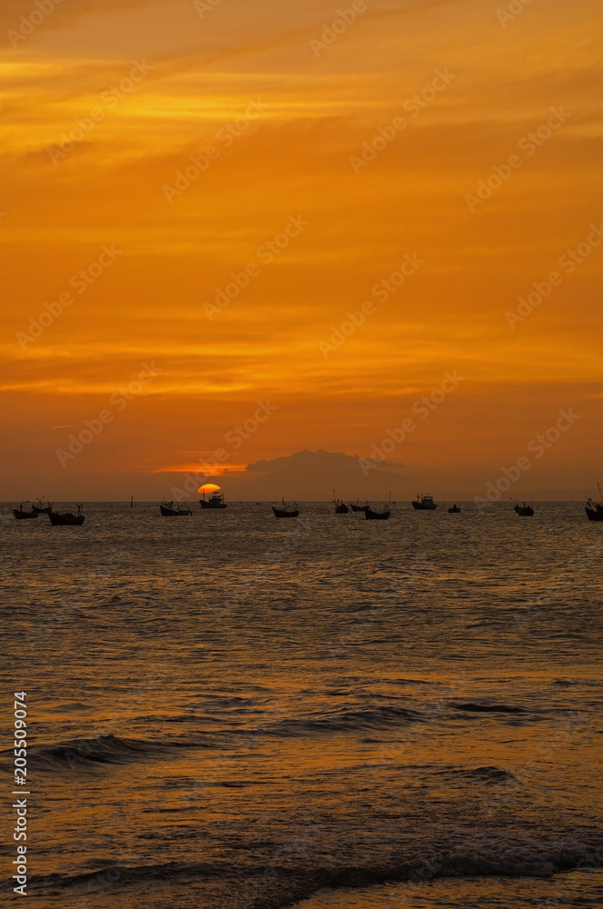 Sunset over the water off the coast of the beach at Mui Ne in central south Binh Thuan Province, Vietnam
