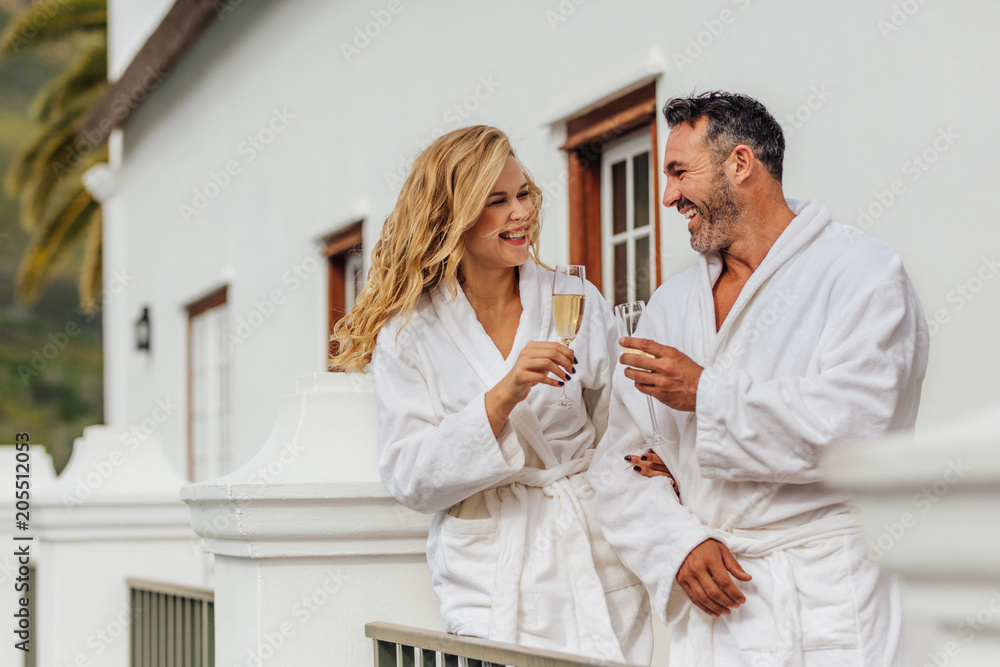Beautiful couple in bathrobe having wine Beautiful couple in bathrobe having wine