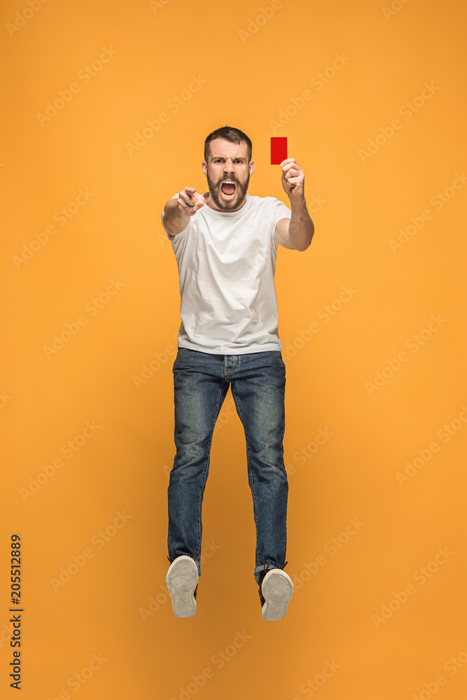 Football supporter with red card on orange background Football supporter with red card on orange background