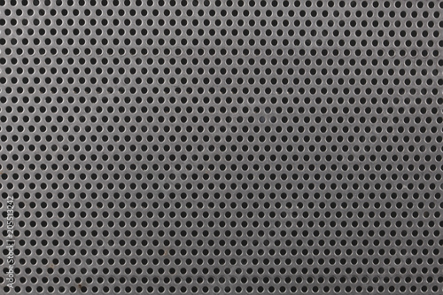 close up on a mettalic texture with small holes photo