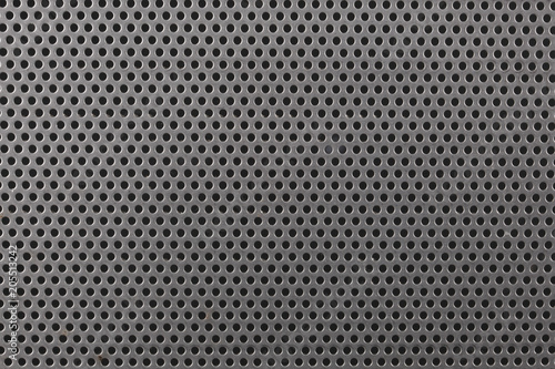 close up on a mettalic texture with small holes
