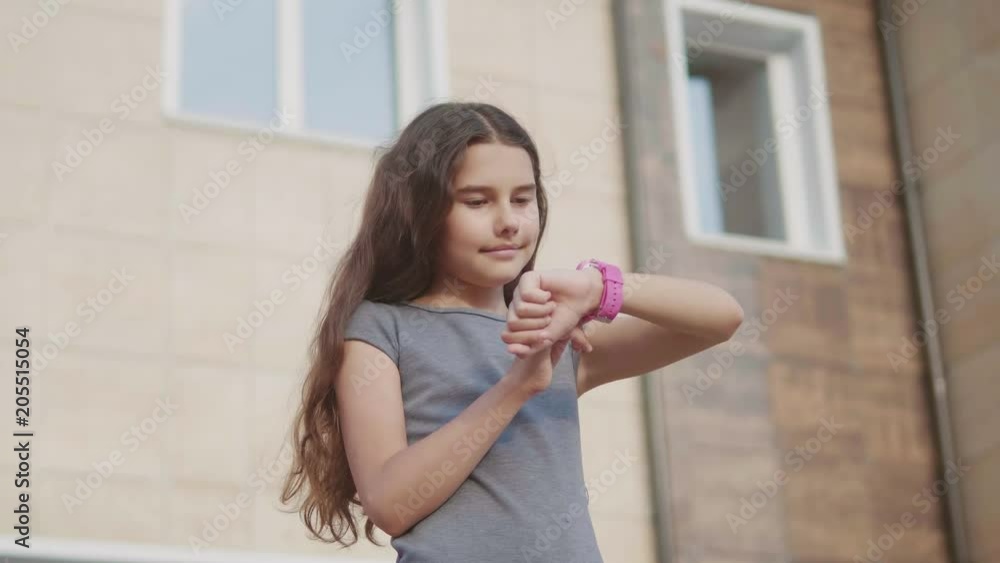 girl schoolgirl looking slow motion video at smart watch waiting for class to start lessons. little girl teenager internet social network on smart clock. school education concepts lifestyle girl schoolgirl looking slow motion video at smart watch waiting for class to start lessons. little girl teenager internet social network on smart clock. school education concepts lifestyle
