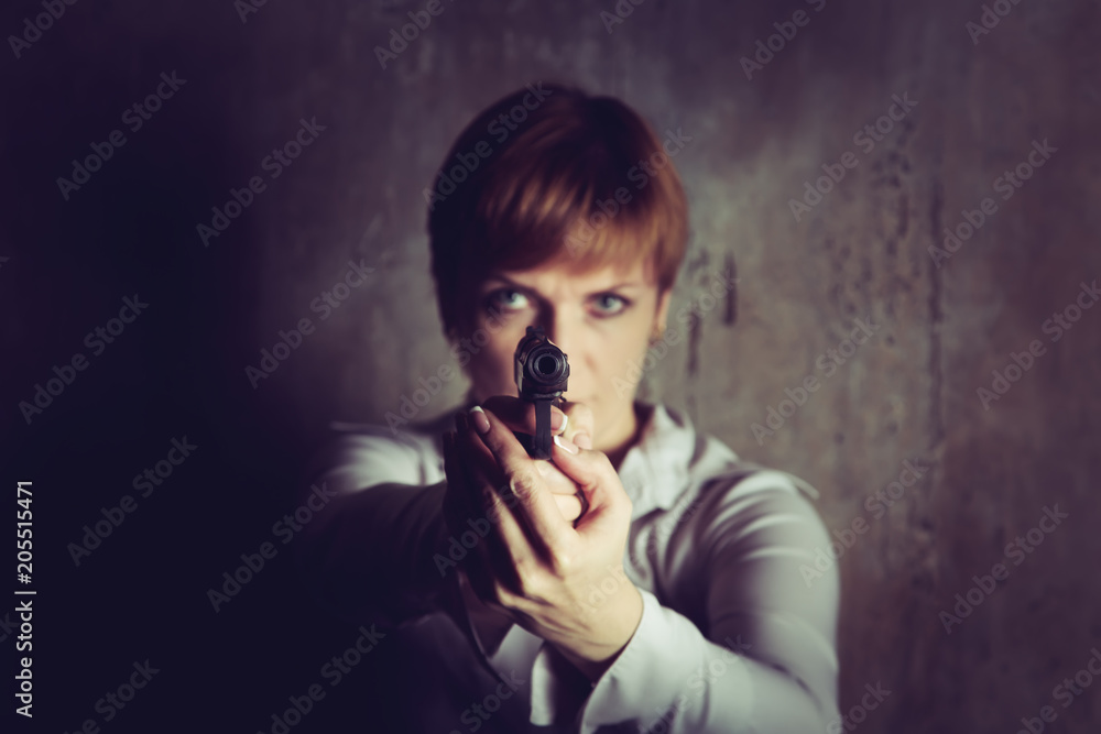 Woman with short hair aims a pistol.