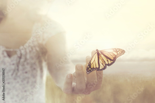 Photo a butterfly leans on a hand of a girl in the middle of nature
