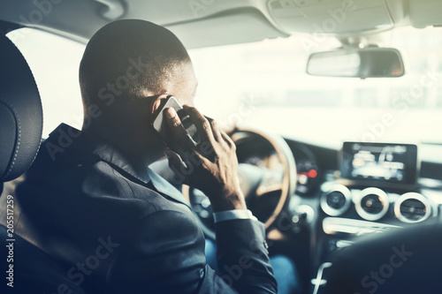 African businessman driving in the city talking on his cellphone