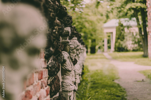 Fototapeta Naklejka Na Ścianę i Meble -  Faces on the wall in park, Arkadia Poland