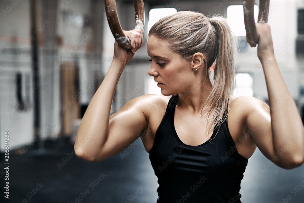 Fit Young Woman Sweating during a Gym Workout with Rings Stock