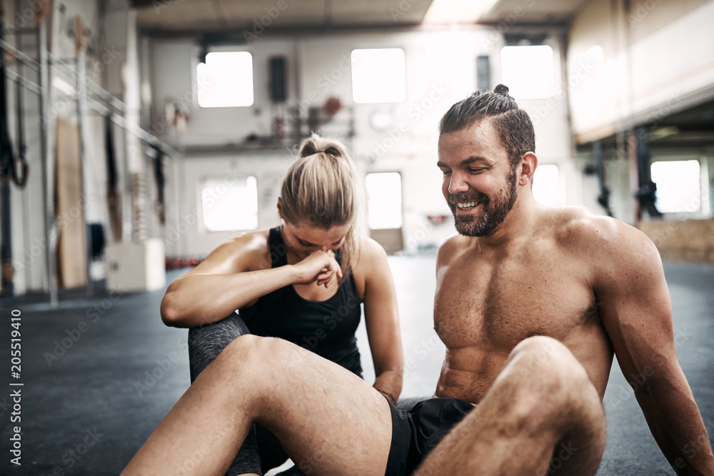 Fit people laughing while taking a break from working out Fit people laughing while taking a break from working out